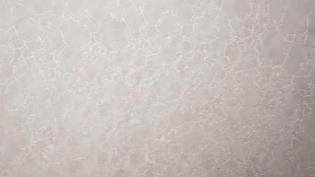 Footage white foam with bubbles rotate close up
