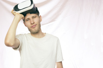 young bearded handsome smiling man holding the vr glasses isolated