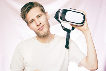 young bearded handsome smiling man holding the vr glasses isolated