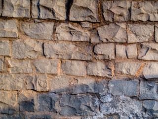 wall of gray stones, pattern, texture, lit by the sun