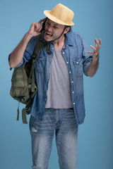 Young bearded man backpacking traveller in blue background.