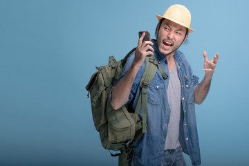 Young bearded man backpacking traveller in blue background.