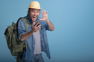 Young bearded man backpacking traveller in blue background.