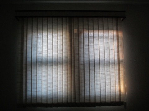 interior of a house, with the view of the window covered by a curtain and the sunlight