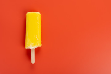 yellow popsicle on a red background