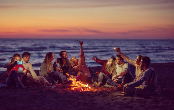 a group of friends enjoying bonfire on beach