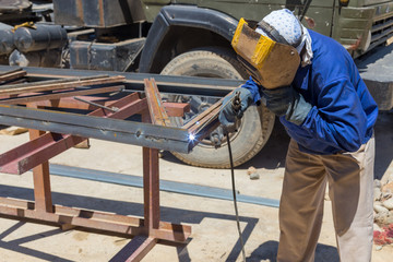 Welder at the factory working with metal construction