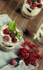 Happy breakfast - yogurt with muesli and berries on a wooden table