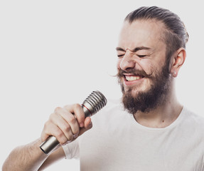 lifestyle and people concept: young man singing with microphone