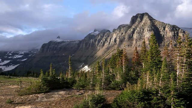 late afteroon light on mt pollock and bishops cap on a stormy day at glacier national park in montana, usa