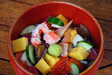 Bowl of chirashi sushi with mixed raw fish and salmon roe over rice