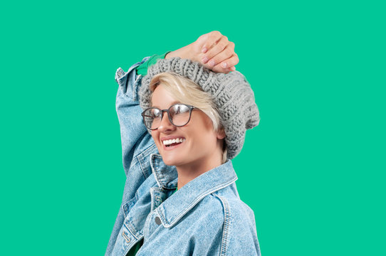 Happy Beautiful Girl In Fashionable Jeans Jacket And Hat On Green Background.