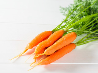 Bunch of fresh carrots on a wooden rustic table.