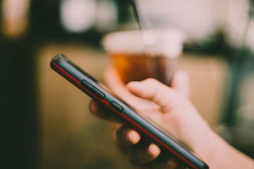 Woman hand using smartphone or tablet to do business, financial or trading stock forex market in park outdoor nature road background.