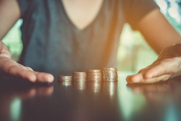 Gold coins on table and green nature bokeh background.