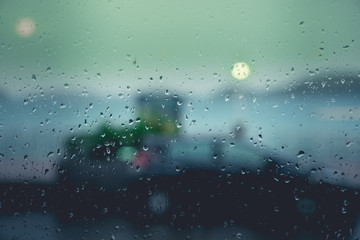 Water from rain drop on glass with blur road and sea view background.