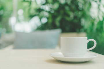 White cup on wood table in cafe.