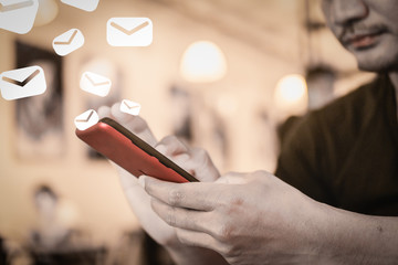 Man hand using smartphone to do work email notification alarm pop up and send it out in cafe.