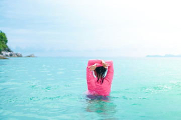 Freedom Woman playing at summer beautiful beach feel relax and fun with blue sky.