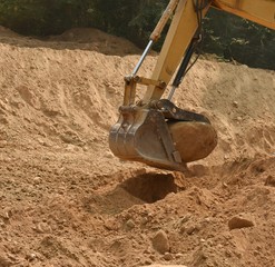 Trackhoe bucket lifting big boulder  © Joylyn McChesnie