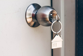 Property Concept, Home key with metal house keychain in keyhole