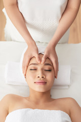 Obraz na płótnie Canvas Hands of beautician massaging face of pretty female client