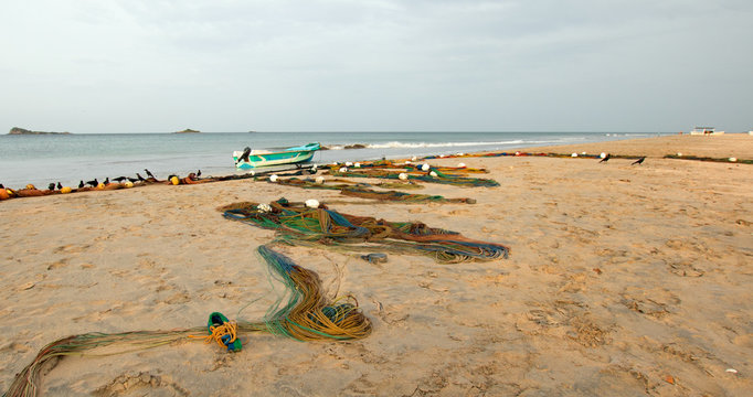Fishing boat next to fishing nets drying on Nilaveli beach in Trincomalee Sri Lanka Asia