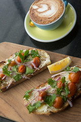 Open sandwich, toast, bruschetta with goat cheese, sun-dried tomatoes and arugula, served on the wooden Board. Healthy eating