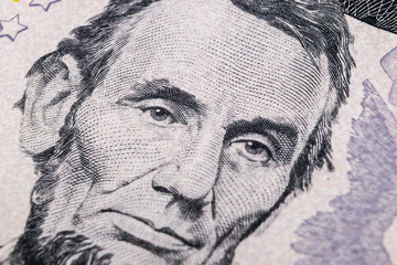 Close up view Portrait of Abraham Lincoln on the one five dollar bill. Background of the money. 5 dollar bill with Abraham Lincoln eyes macro shot. Money background. Face portrait