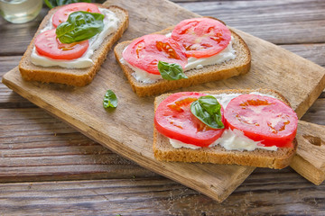 Crostini with toasted gray bread, cottage cheese and slased tomatoes .