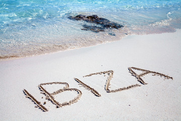 The inscription of Ibiza on the beach of white sand
