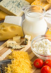 Cheeses, Cherry Tomatoes and Milk on the Wooden Platter - Close