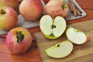Naklejka na ściany i meble Ripe apples, chopped apple on a cutting board, autumn harvest concept.