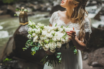 Bride holding in hands big bouquet with white roses