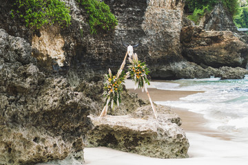 Beach wedding ceremony in Boho style decorated with cow skull, yellow roses and dry wildflowers