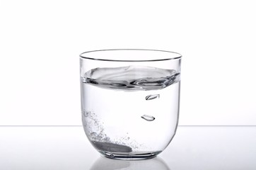 Effervescent Pill in a Glass of Water on the Table