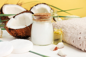 Fresh homemade coconut milk in glass jar, oil and nut for skin treatment, hair care, bathroom towel. Home spa with holistic coco nut products, healing lotion recipe. Safe, natural, aromatic.