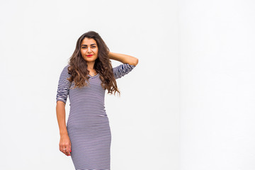 Beautiful hispanic young woman in black and white striped dress at city. Autumn or spring fashionable trend