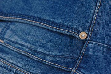 part of the blue denim pants with pockets and rivets, close-up