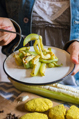 Woman hands holds with fork baked or cooked eggplant slices on plate. Vegan lunch, vegetarian healthy food dietary dinner