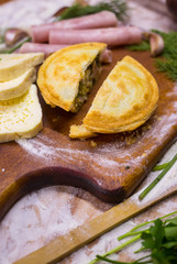 Beef, chicken, ham and cheese closed pie or tart with onion, garlic and spices break into half pieces. Yummy and crispy pie. Takeaway fast food 