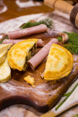 Beef, chicken, ham and cheese closed pie or tart with onion, garlic and spices break into half pieces. Yummy and crispy pie. Takeaway fast food 