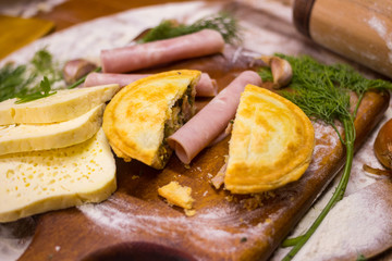 Beef, chicken, ham and cheese closed pie or tart with onion, garlic and spices break into half pieces. Yummy and crispy pie. Takeaway fast food 
