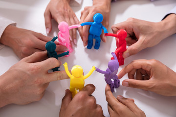 Group Of Businesspeople Holding Human Figures