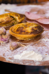 Golden crusty brown mushrooms vegetable closed pie. Yummy take away tart with stuffing and sesame seeds on wooden board. Hipster street fast food lunch concept