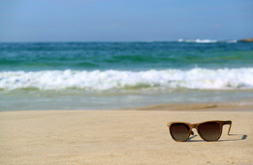 Sunglasses on the sandy beach with blurred Atlantic ocean in background, Rio de Janeiro, Brazil, South America 