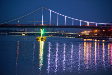Blinking lights on night bridge, sparkle in water reflection