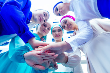 a group of five young and attractive business women in Muslim dress multi-colored hijab and a...