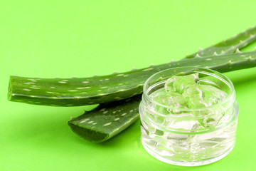 Obraz premium Natural beauty products and plant based clinical treatment concept with macro close up on an aloe vera plant leaf and gel isolated on green background