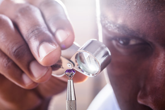 Jeweler Examining Diamond Through Loupe